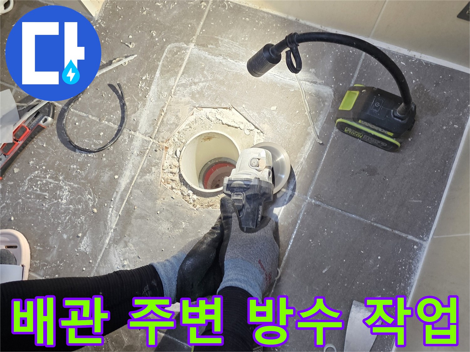 손상된-배수구 주변의 타일을 제거하고 배관 내부를 청소하는 모습입니다.