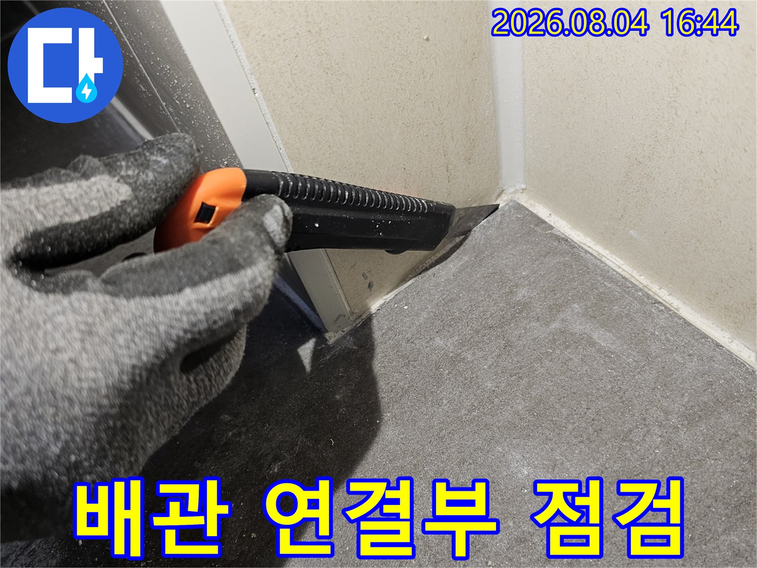 작업자가 장갑을 끼고 배관 연결 부위의 상태를 세밀하게 확인하는 모습