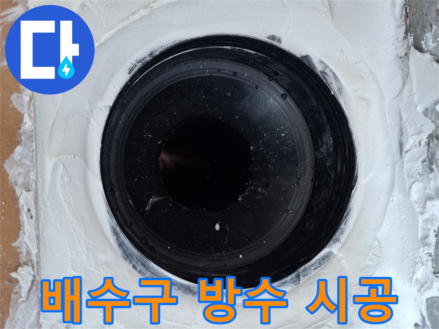 검은색 우수관 주위에 흰색 방수재를 두껍게 충진한 사진입니다.