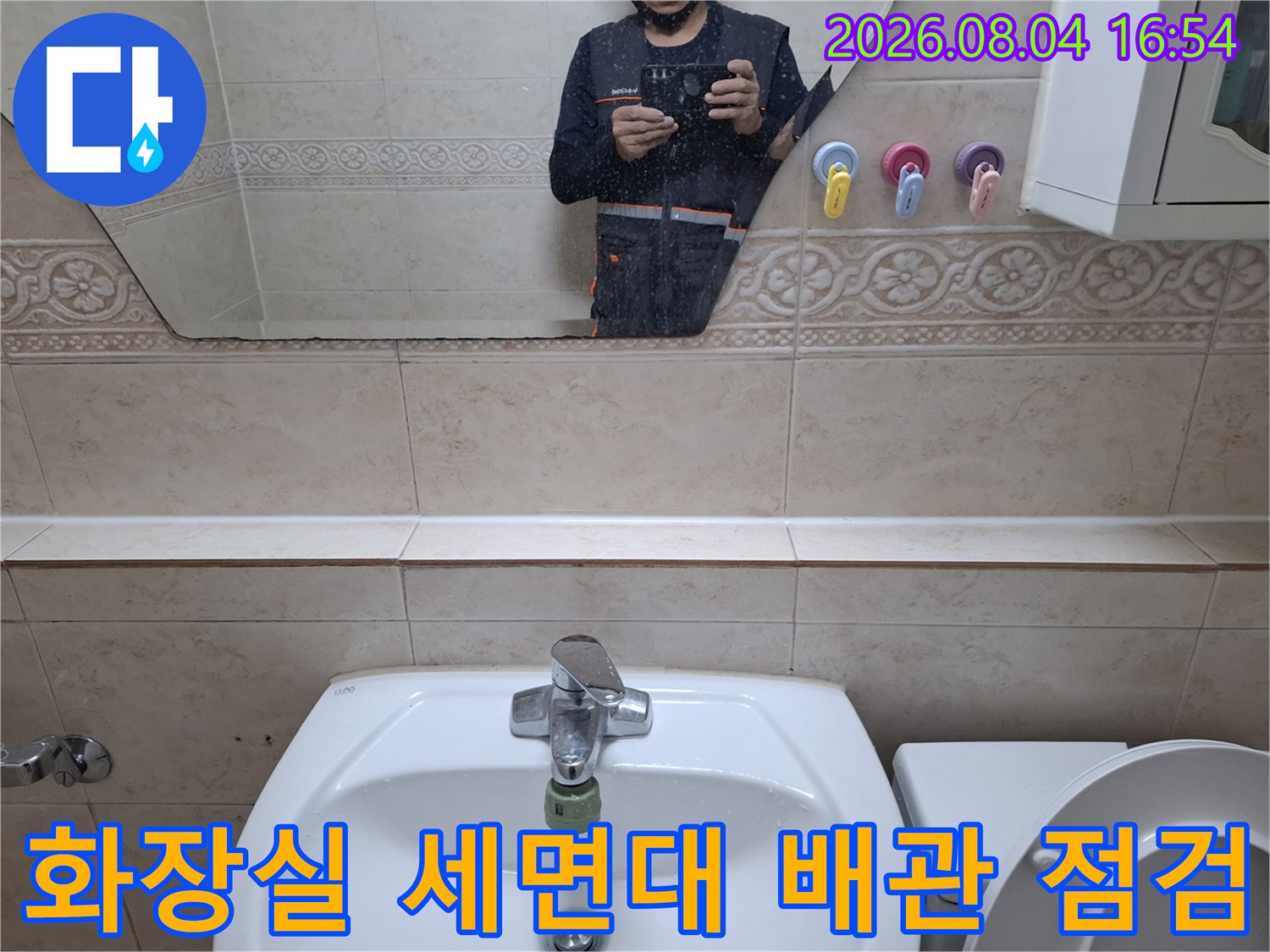 세면대 아래쪽 배관 연결 부위와 수전 주변을 점검하는 모습
