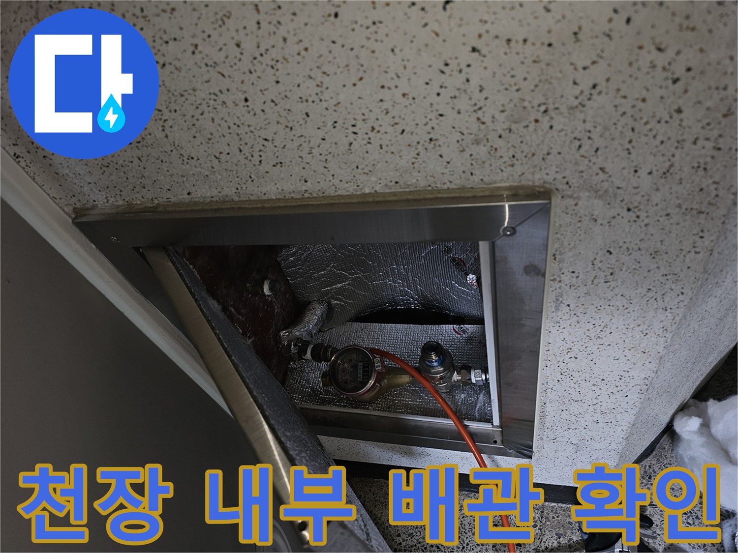 화장실 천장 점검구 안쪽의 보온재 처리된 배관과 압력계 - 누수 진단을 위한 공압 장비 설치