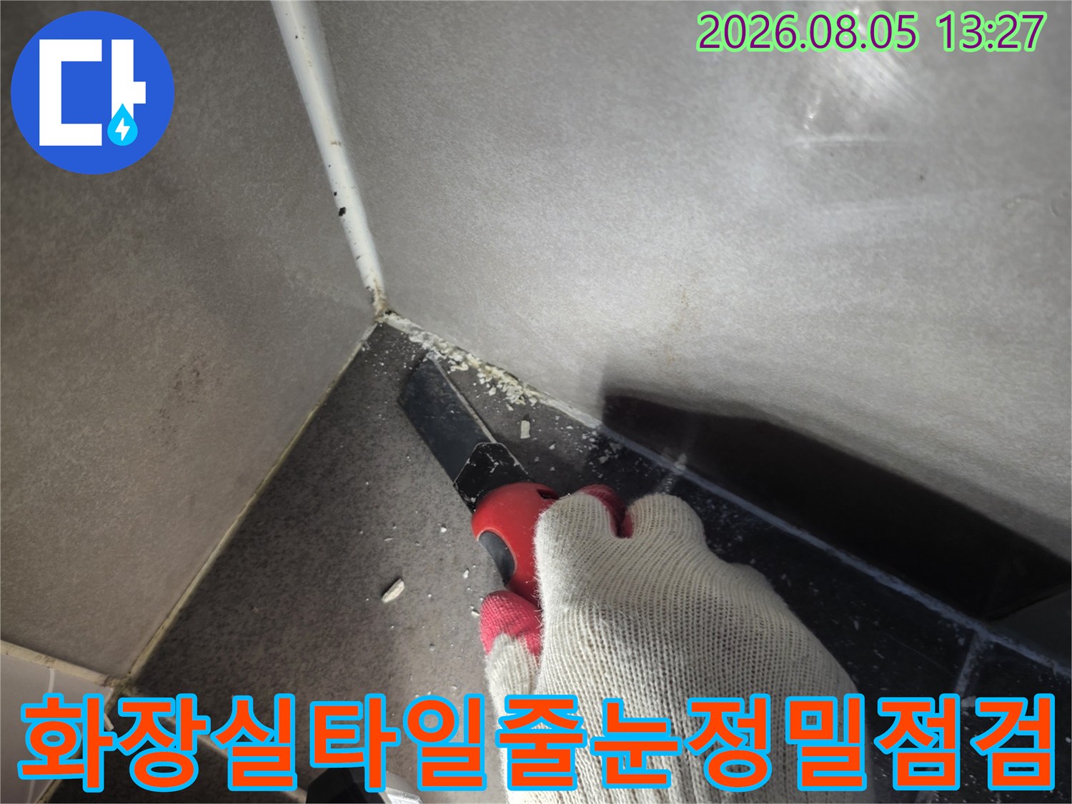 작업자가 장비를 사용하여 화장실 타일 줄눈 부위를 정밀 점검하는 모습