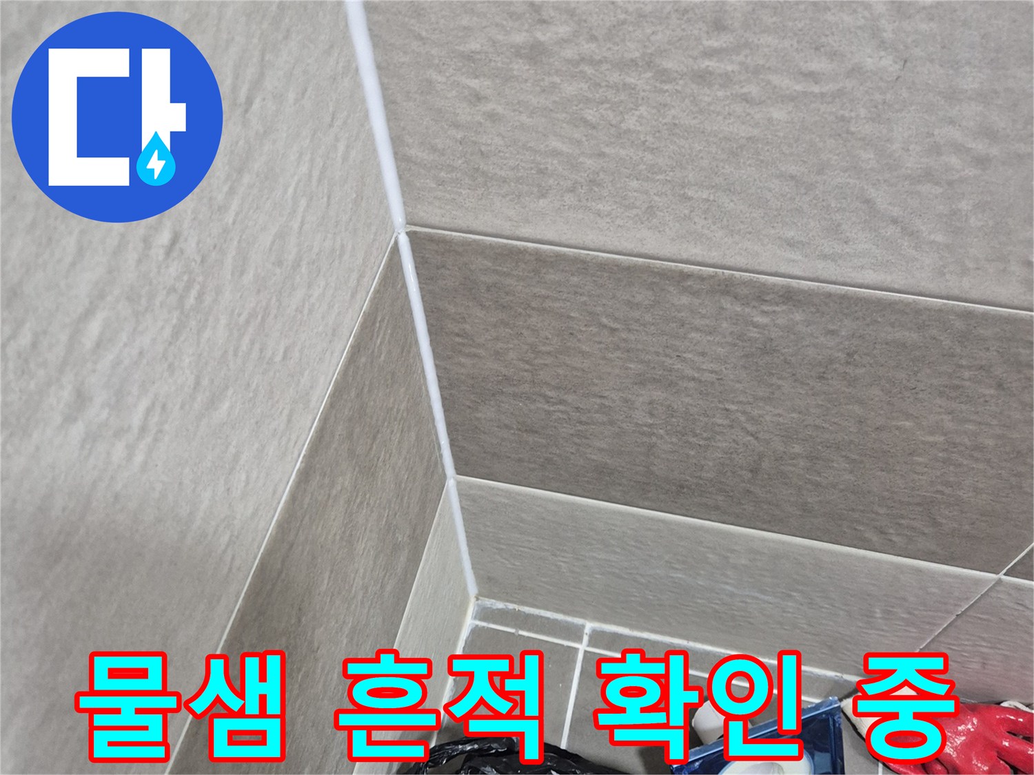 타일 줄눈 사이의 습기와 물샘 흔적을 조사하는 현장 사진