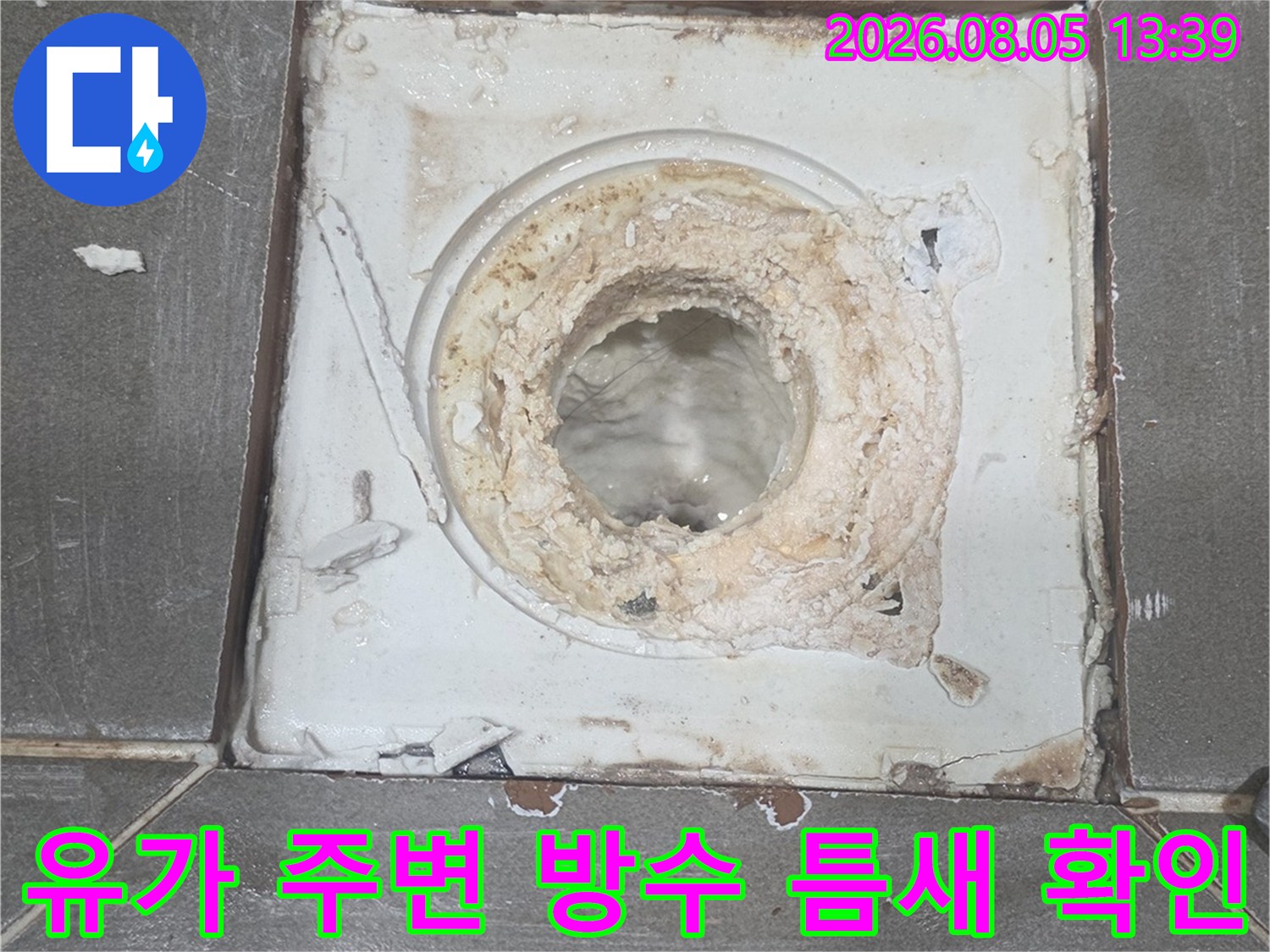 화장실 바닥 배수구 유가 부위의 노후된 시멘트와 균열을 촬영한 점검 사진입니다.