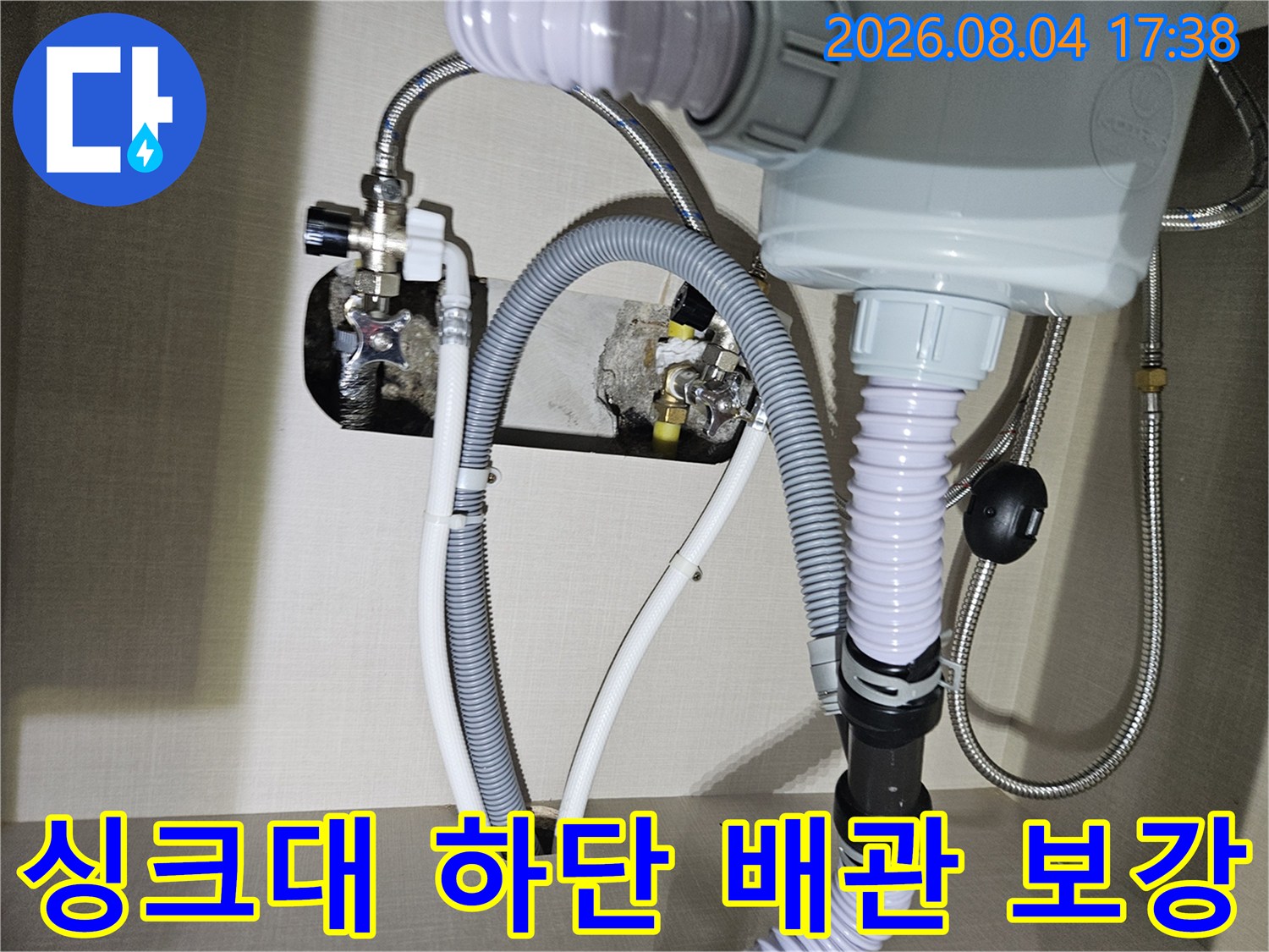 싱크대 아래 노출된 온수 및 냉수용 호스와 연결부 배관을 교체하는 사진