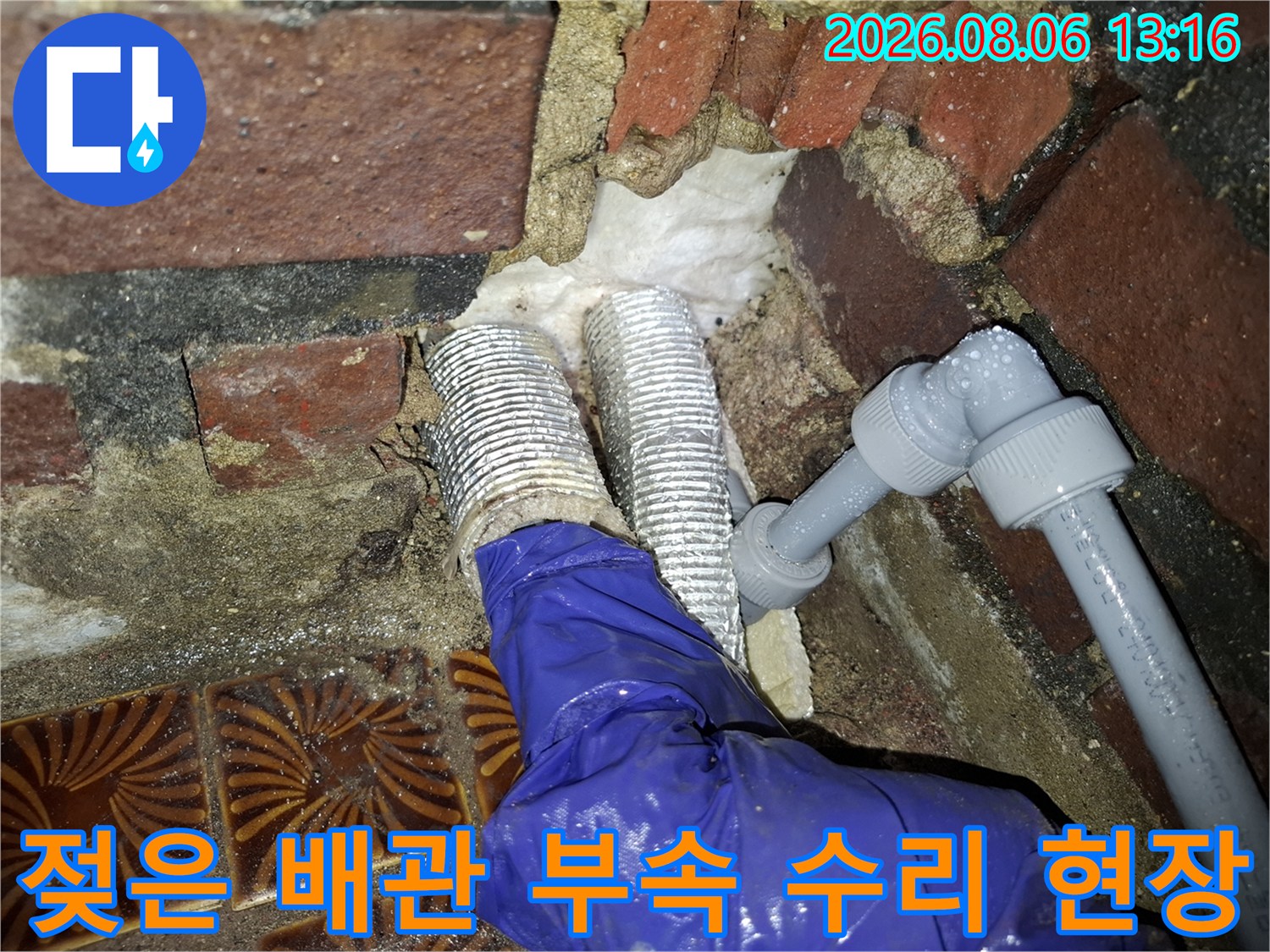 물에 젖은 은색 배관 부속과 파손된 연결부의 클로즈업 사진