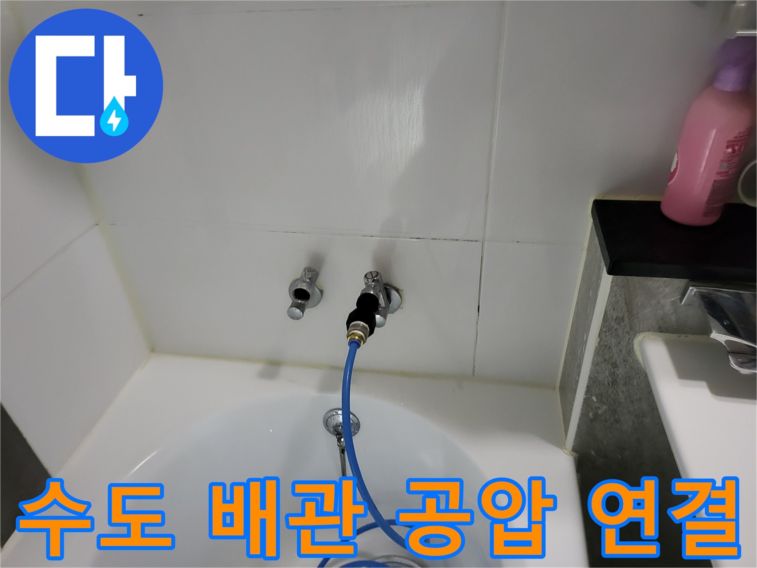 욕실 벽면 수도 부속에-파란색 압력 측정 호스를 연결한 사진입니다.