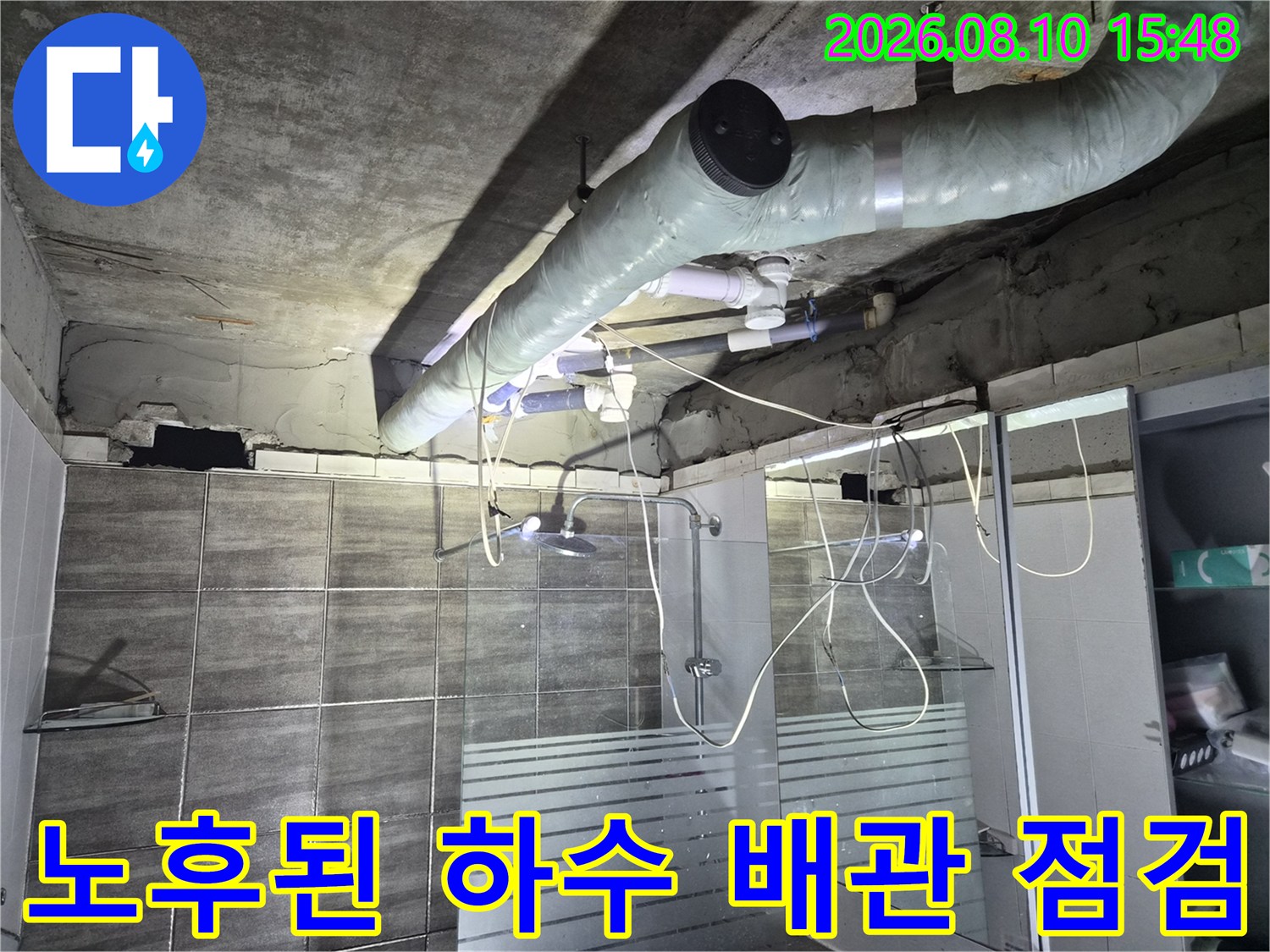보온재로 감싸진 하수 배관과 콘크리트 천장 내부 모습입니다.