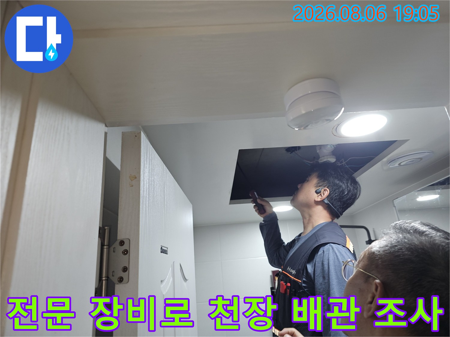 기술자가 청음기를 사용하여 천장 내부의 파손된 배관 위치를 확인하는 모습