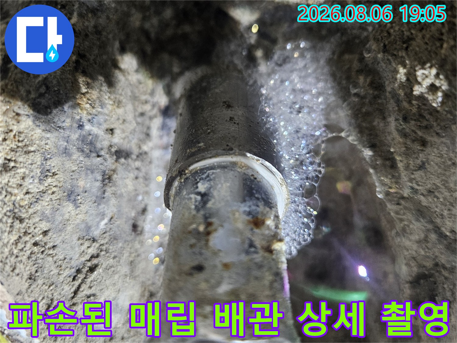 벽면 내부의 손상된 배관 부위를 근접 촬영한 사진