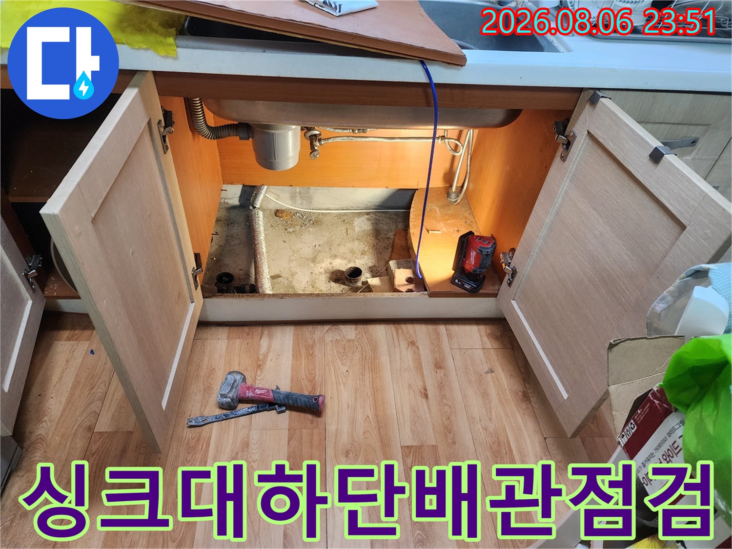싱크대 하부장 내부의 배관 구조와 작업용 전동 드릴