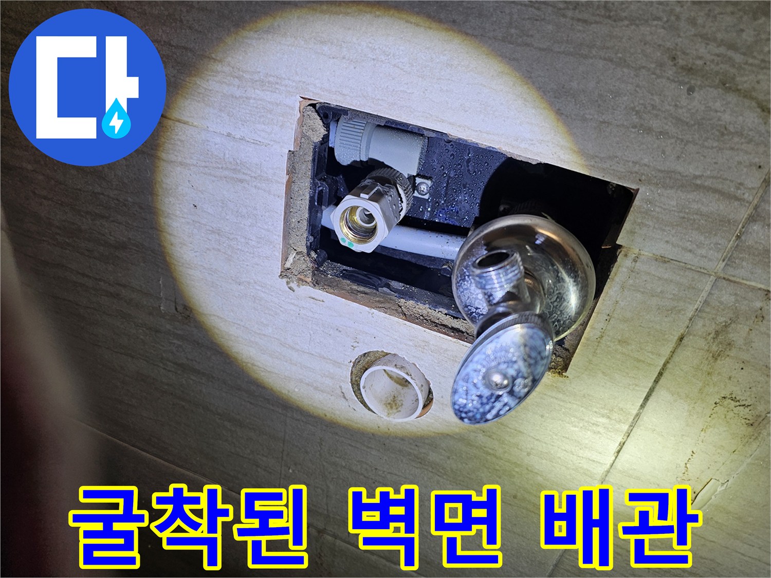 세면대 하단 타일 제거 후 노출된 수도 부속과 배관 연결부