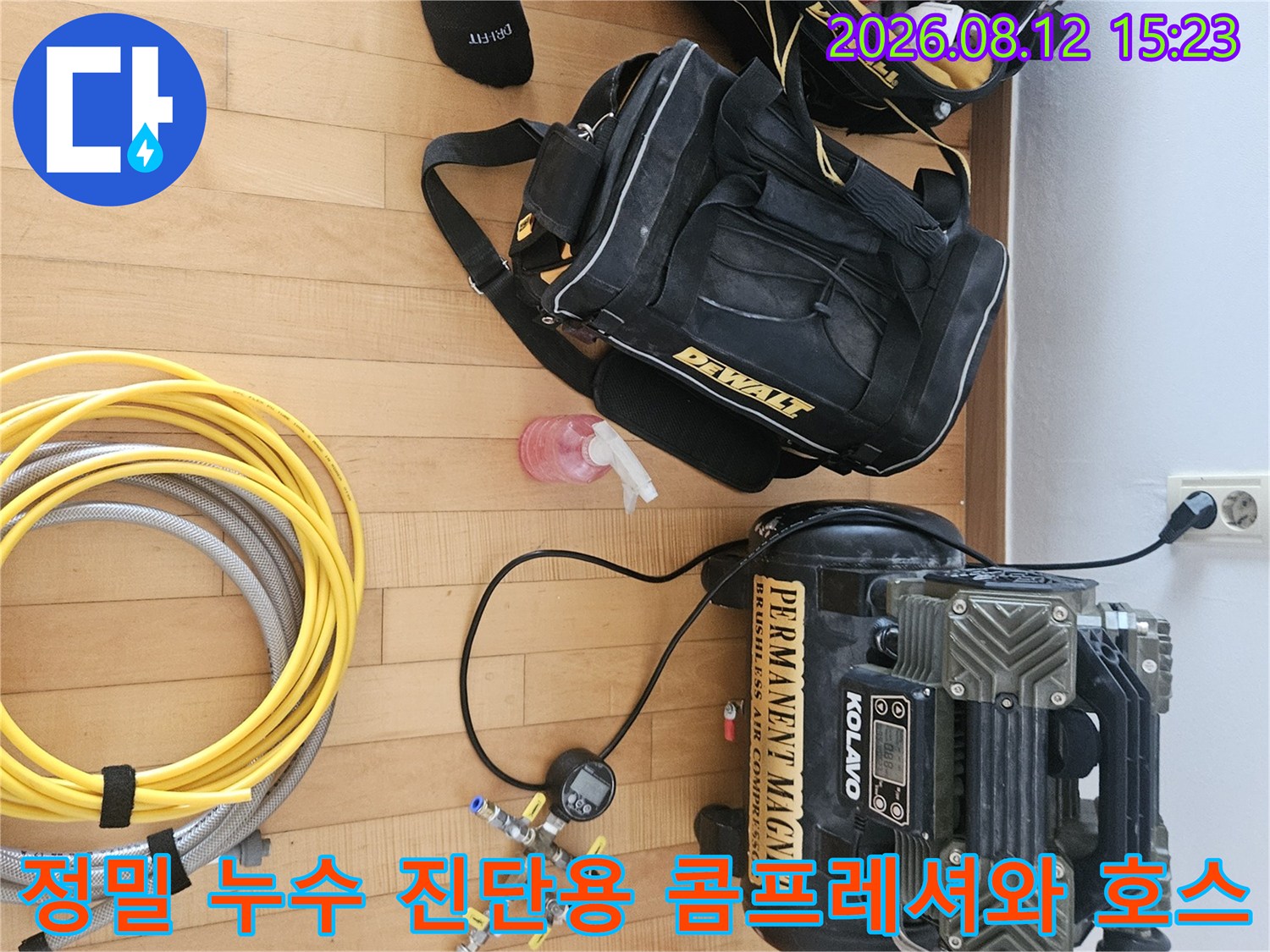 누수 검사를 위해 바닥에 정렬된 공압 장비-노란색과 주황색 배관 호스가 연결된 상태