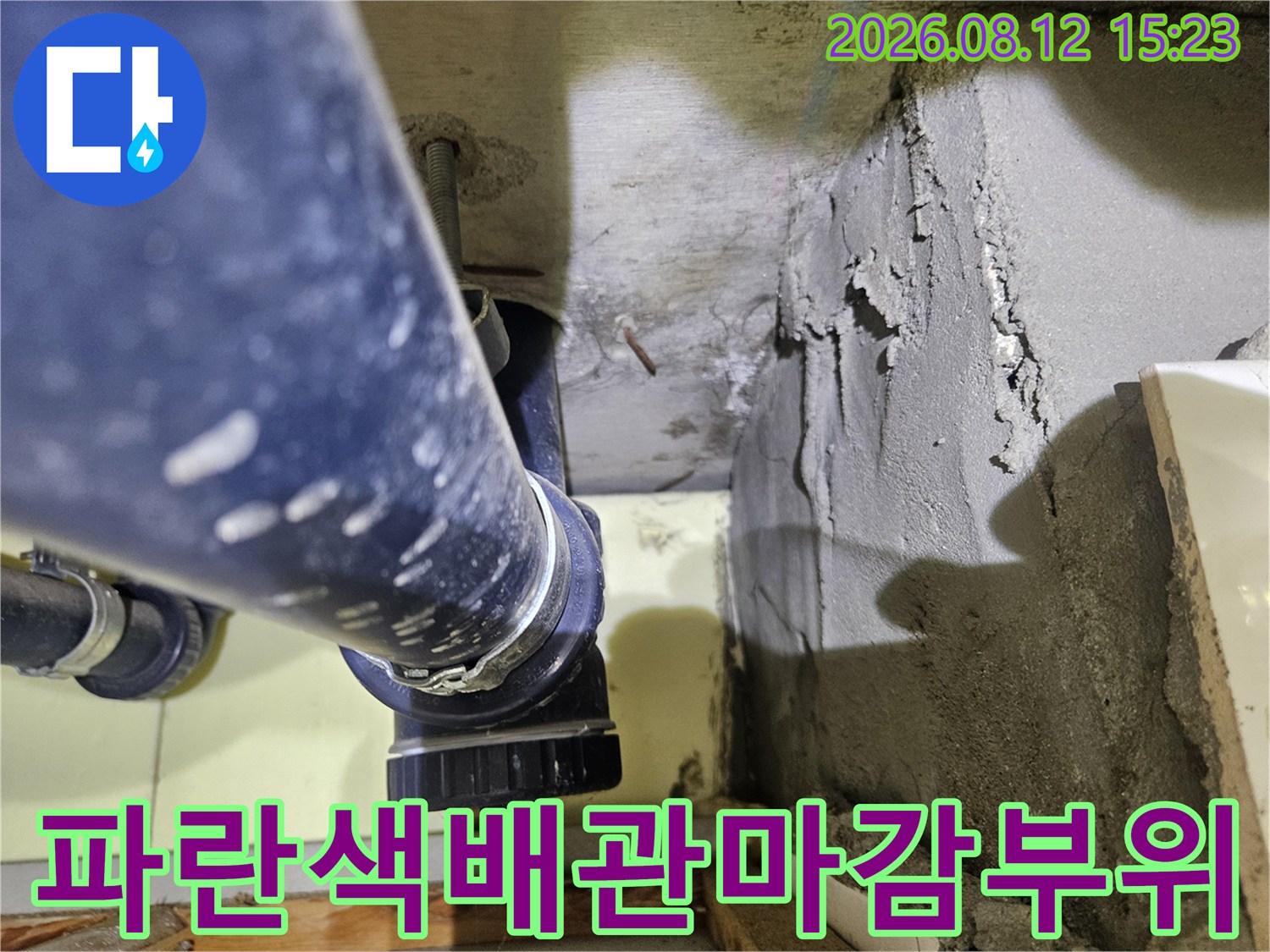 천장 속-파란색 배관과 시멘트 벽면이 만나는 지점의 상세 모습