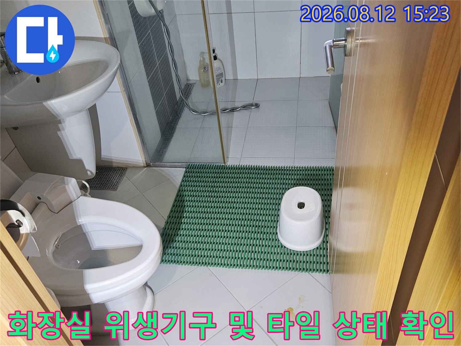 흰색과 초록색 타일이 혼합된 화장실 내부에 설치된 세면대와 변기 사진