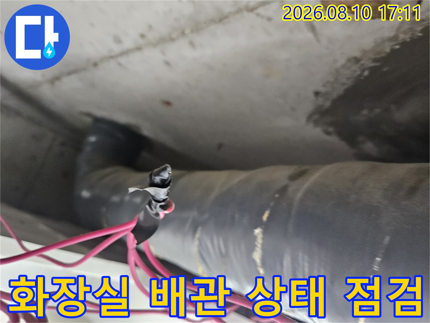 일산동구 아파트 화장실 천장의 검은색 배관과 붉은색 전선이 지나가는 모습입니다.
