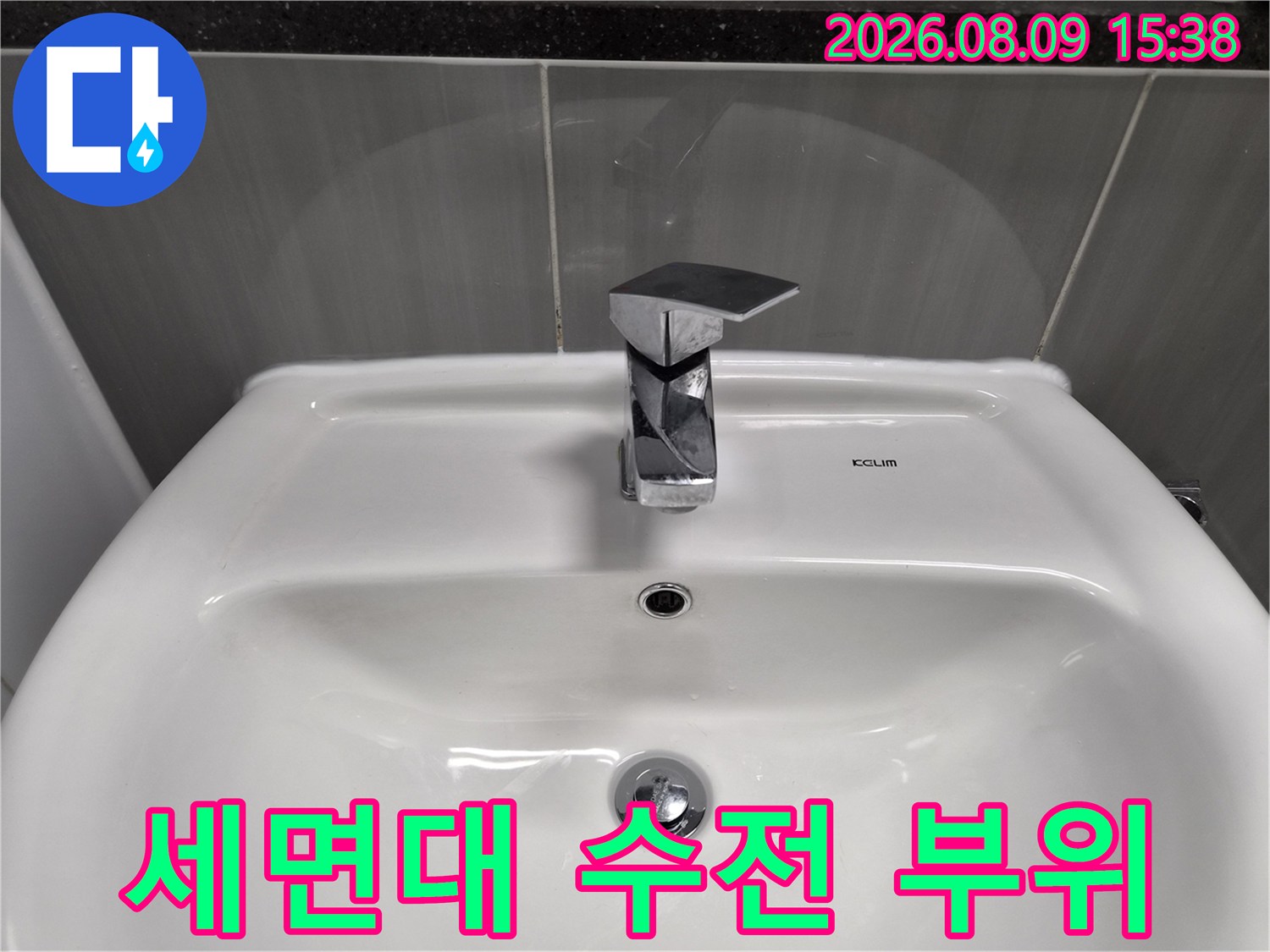 하얀색 세면대에 설치된 은색 수도꼭지 상세 사진입니다.
