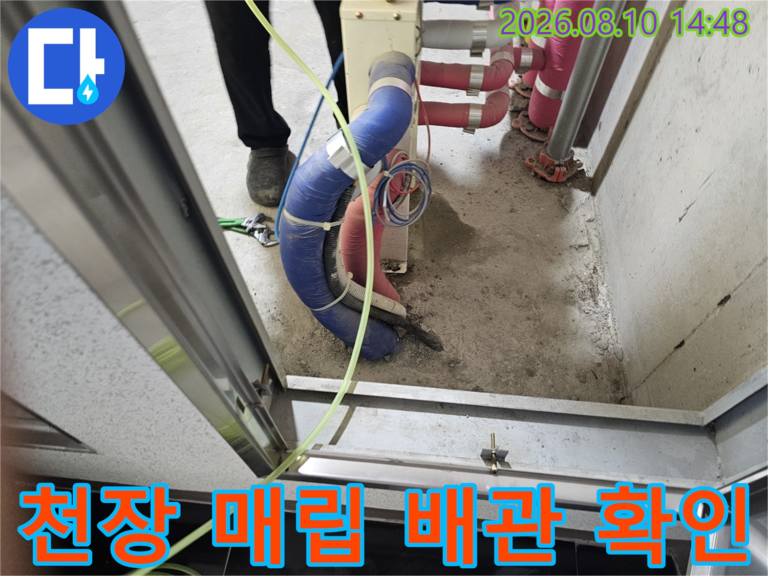 욕실 천장 내부-파란색 보온재가 씌워진 배관의 연결 상태를 점검하는 장면