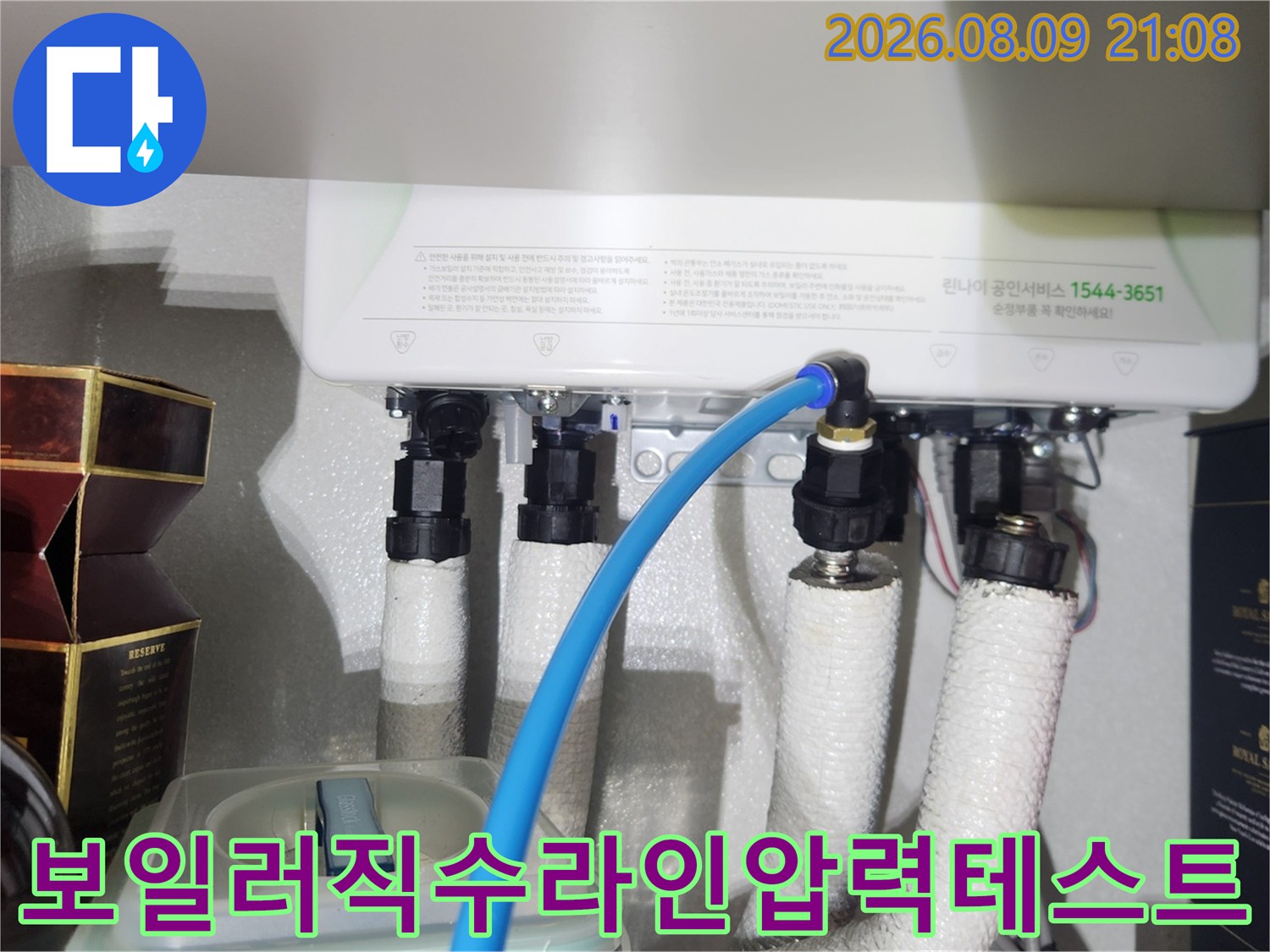 흰색 보온재가 감싸진 배관에 파란색 공압 호스가 연결되어 있는 모습