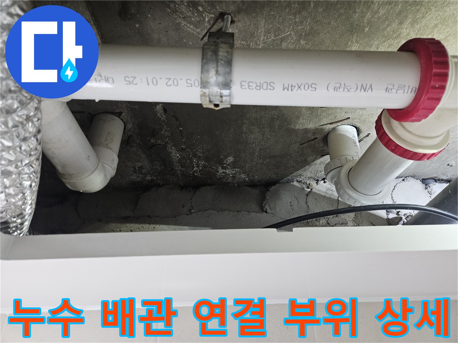 화장실-천장-하수관-연결부의-빨간색-마감재와-파이프