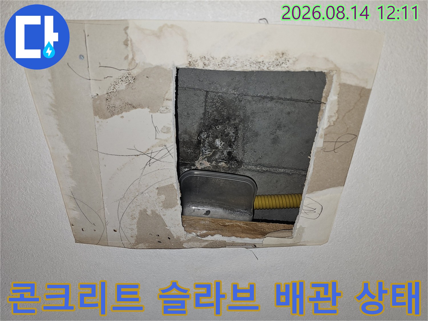 천장 내부 타공 부위의 콘크리트 습기와 노란색 배관 모습