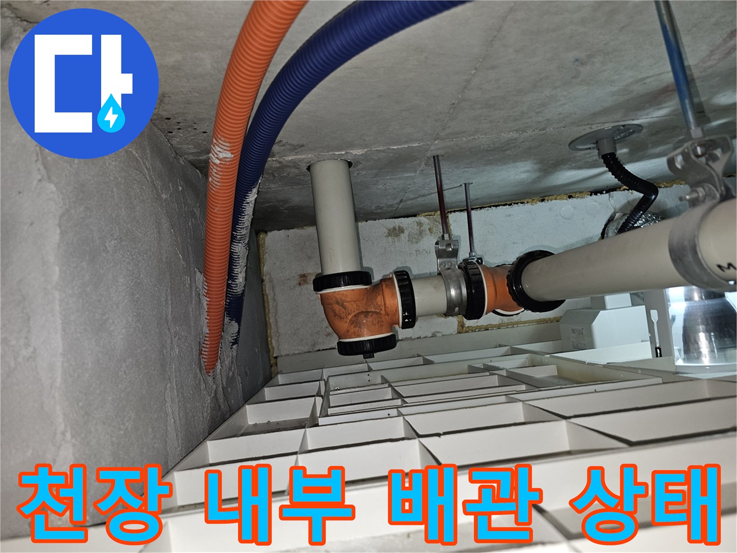 천장 점검구 내부의 전선관과 하수 배관 구조물