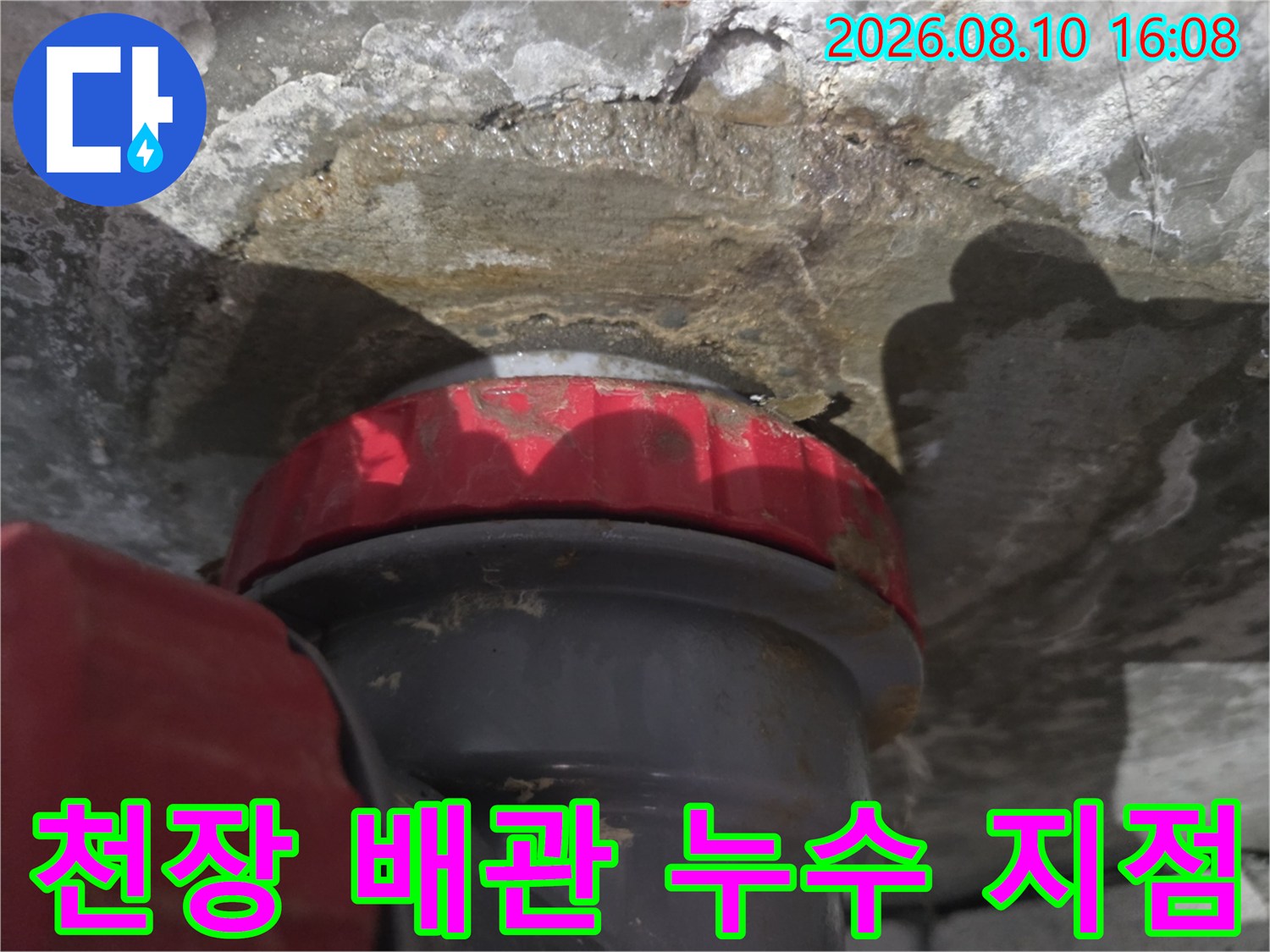 젖은 콘크리트와 붉은색 배관 연결부 상세 사진