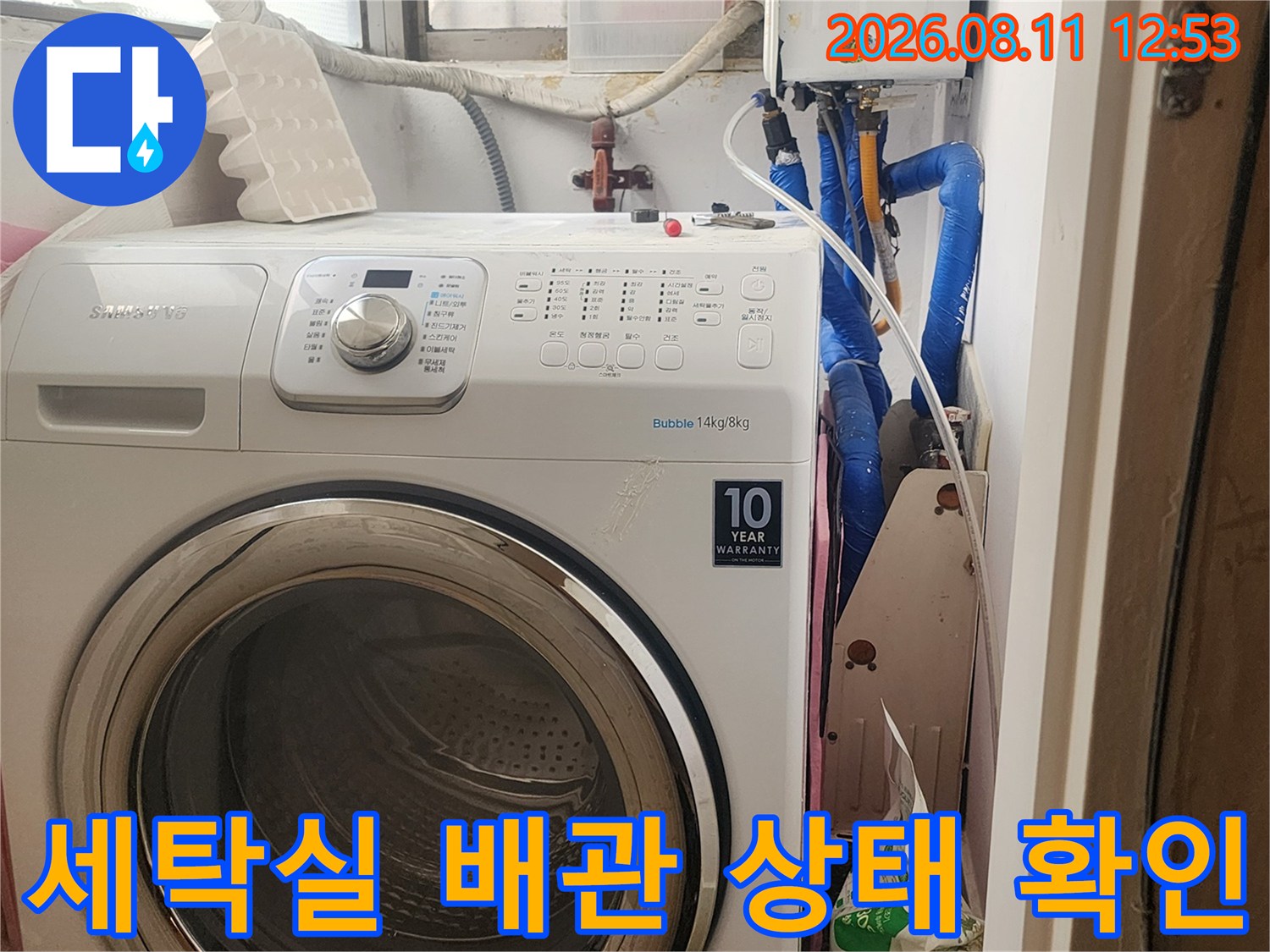 세탁기 뒤편에 위치한 파란색 수도 배관과 보일러 연결 부위 점검 현장입니다.