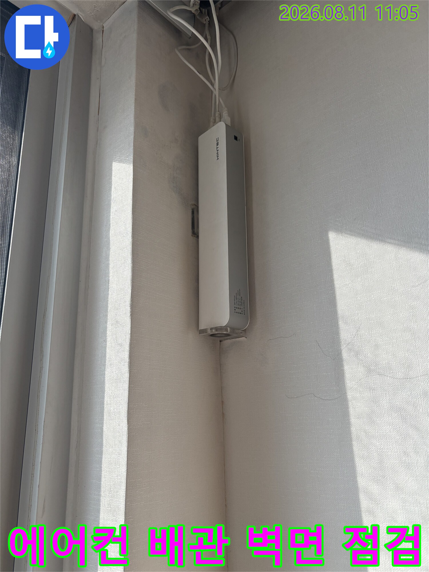 벽면에 고정된 에어컨 배관과 흰색 통신 장비의 근접 사진