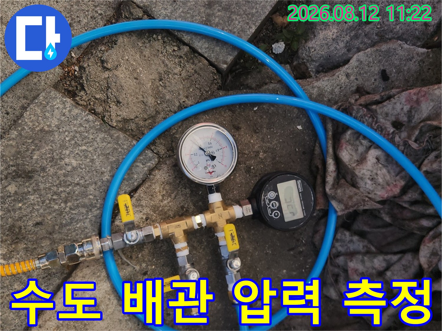 배관 연결 부위에 설치된-압력 게이지와 파란색 에어 호스
