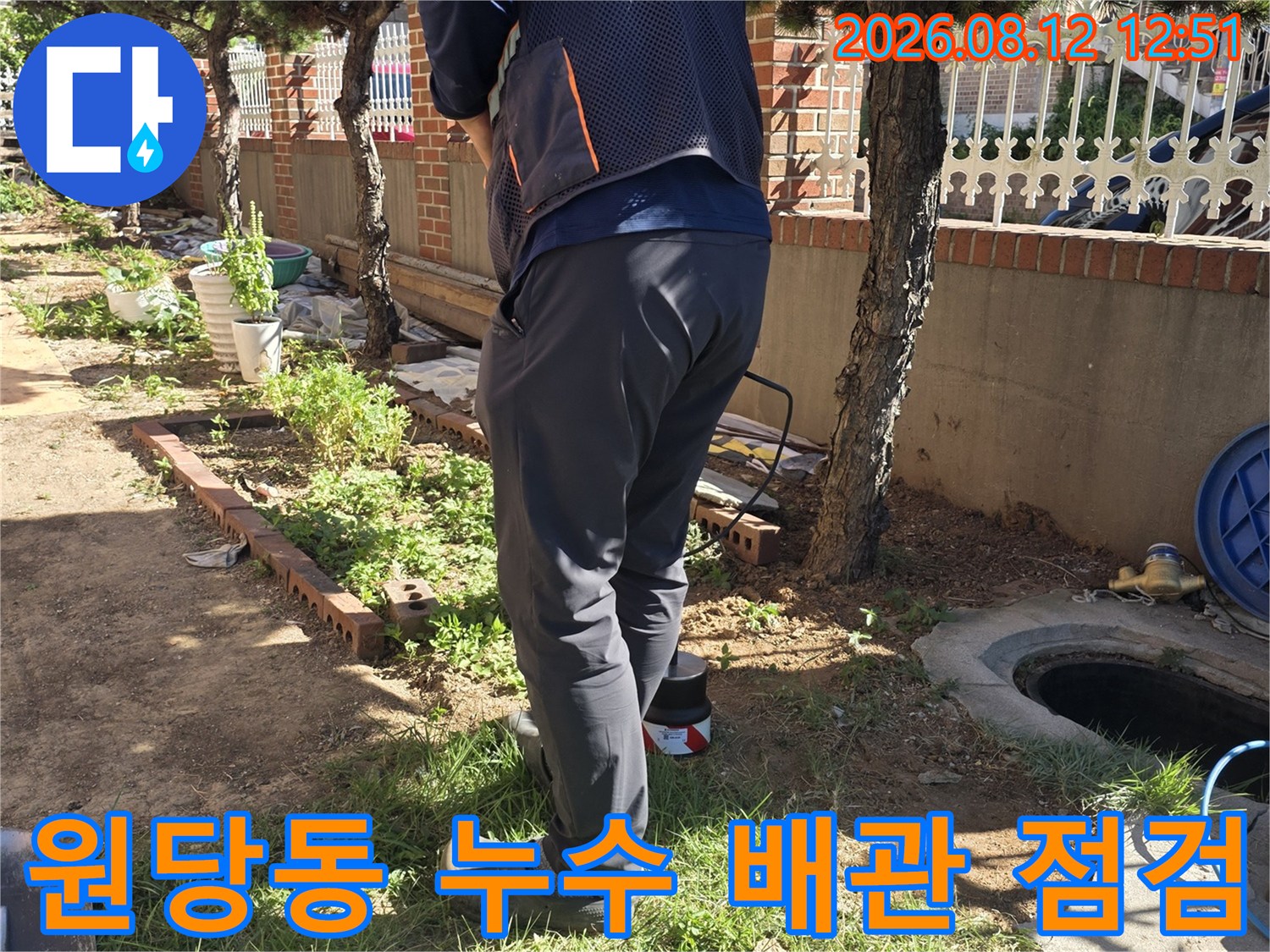 누수 탐지 전문가가 야외 배관 부근에서 정밀 진단 장비를 세팅하고 작업하는 모습