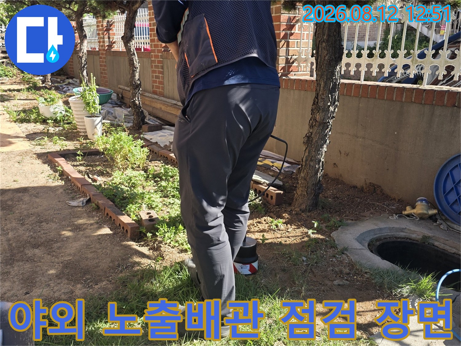 야외로 노출된 파손 배관을 조심스럽게 다루며 수선 준비를 하는 모습