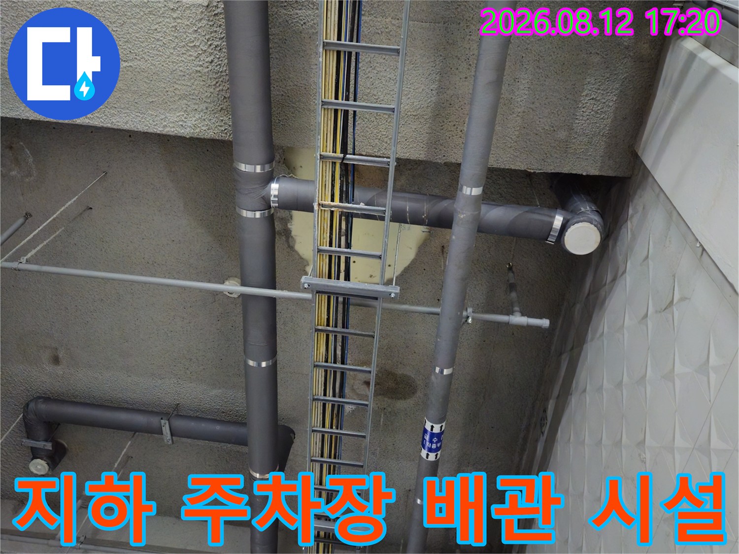 상가 지하 천장에 노출된 배수 파이프 및 전기 설비 구조