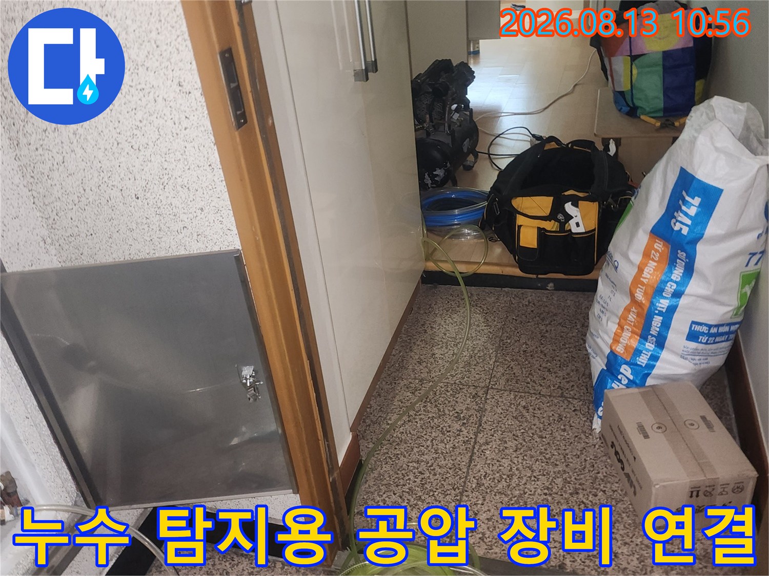 금속제 점검구 덮개 옆으로 설치된 누수 탐지용 호스와 게이지-배관 압력 검사