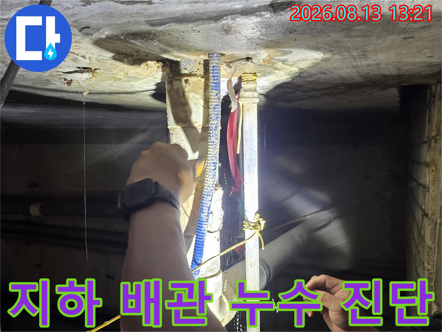 천장 배관 구조물-배관 연결 부위의 누수 여부를 확인하기 위해 점검 중인 모습