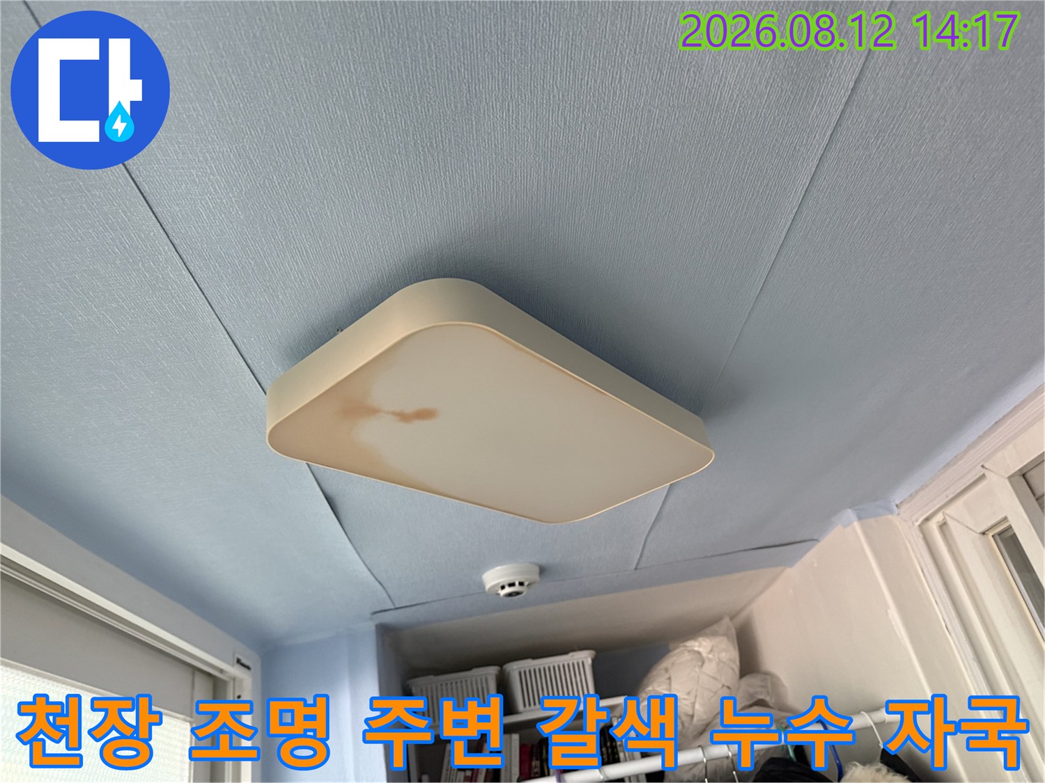 베란다 천장 전등 커버 측면에 나타난 진한 갈색의 물 얼룩과 오염 상태