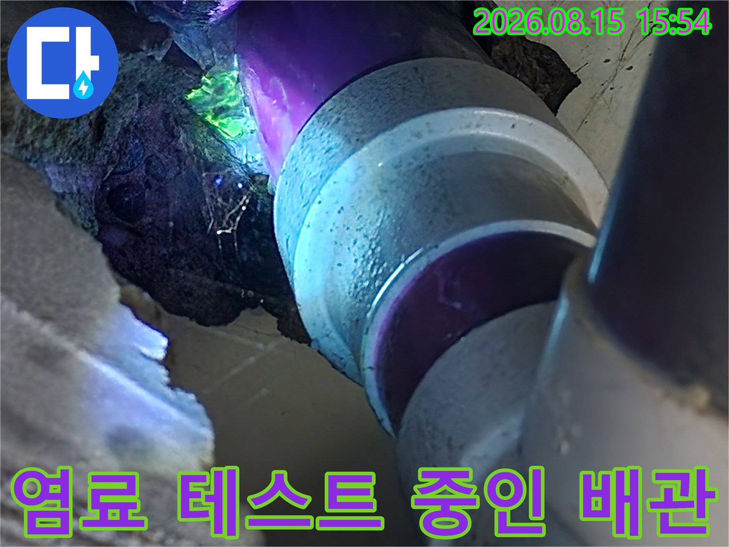 배관 연결 부위에서 푸른색 염료가 흘러나오는 누수 현장 사진입니다.