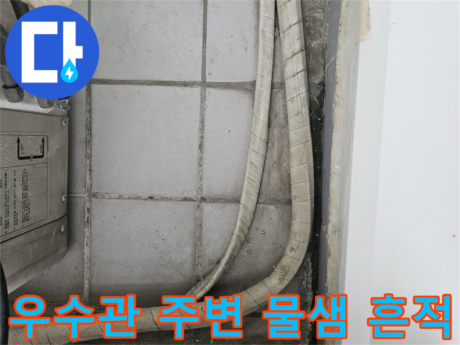 베란다 타일 사이 우수관 주변의 습기와 변색된 상태를 보여주는 사진입니다.