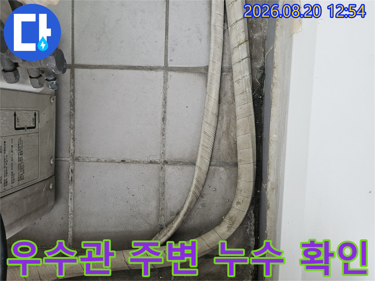 분당 정자동 베란다 우수관 주변의 젖은 타일과 배관 상태를 보여주는 사진입니다.