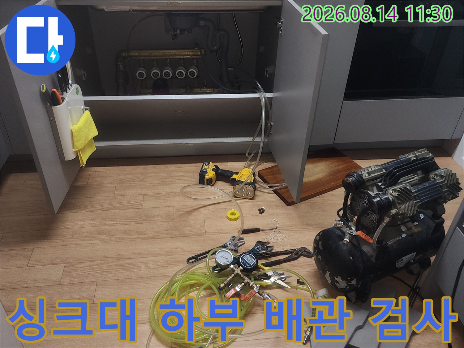 싱크대 밑쪽 배관-공압 검사를 위해 연결된 압력계와 호스들