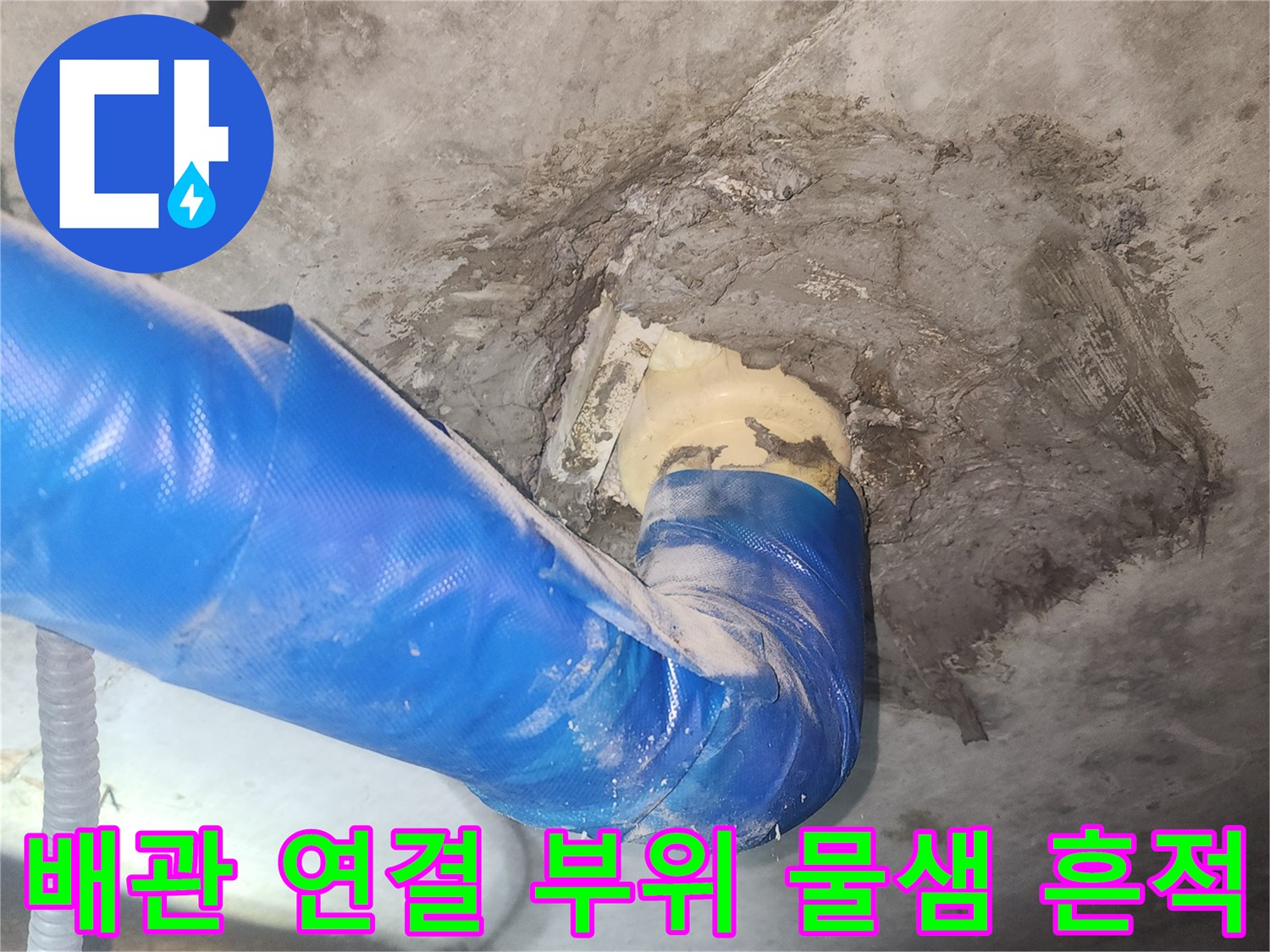 파란색 보온재로 감싸진 배ทด관 주변의 젖은 콘크리트 벽면