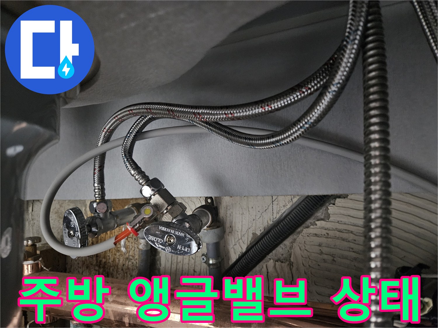 싱크대 하부 배관에 연결된 앵글밸브와 수전 호스 모습