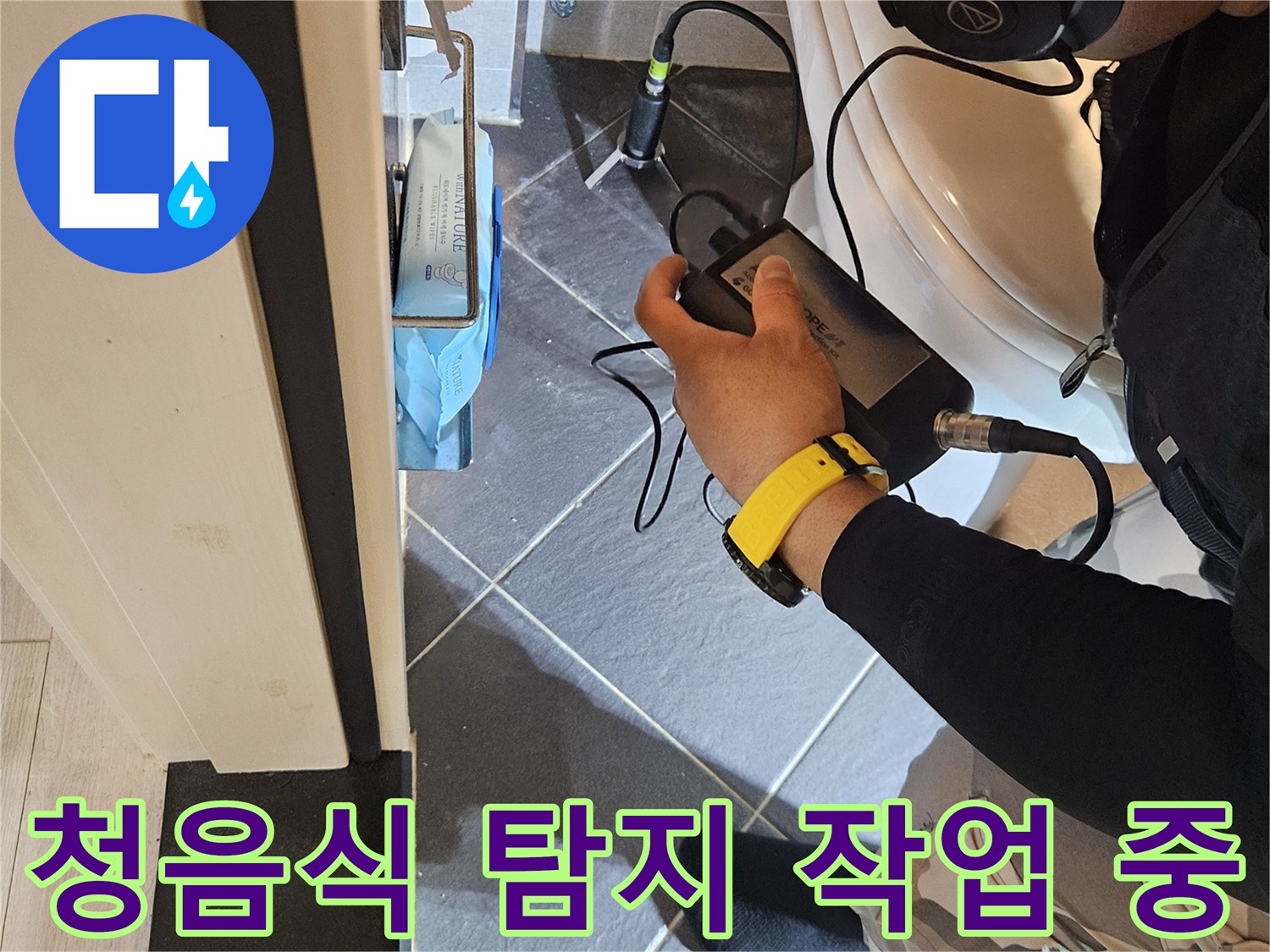 헤드셋을 착용하고 청음식 탐지기로 배관 누수를 찾는 모습