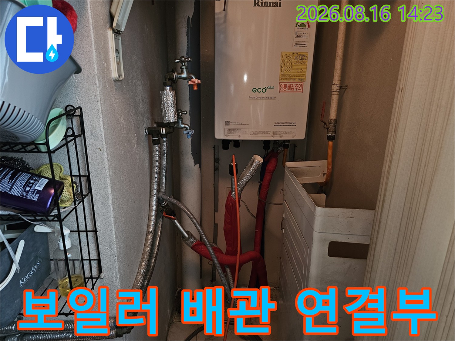 보일러 아래쪽의 은색 보온재가 씌워진 배관과 밸브 부위를 촬영한 사진입니다.