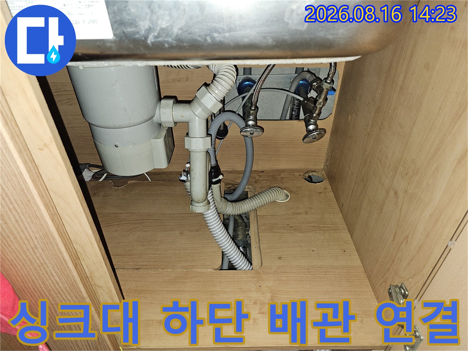 싱크대 하부의 앵글밸브와 회색 배수 호스 모습