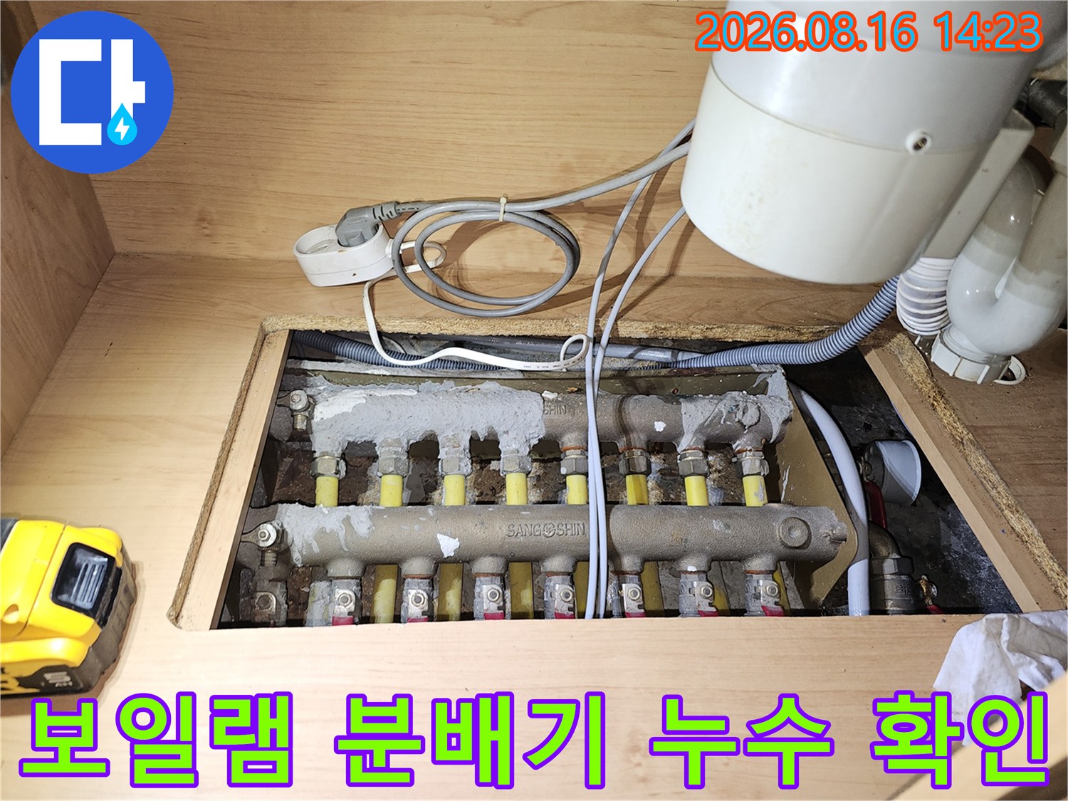 싱크대 하부장 안쪽의 보일러 분배기와 연결된 배관들의 배열을 보여줍니다.