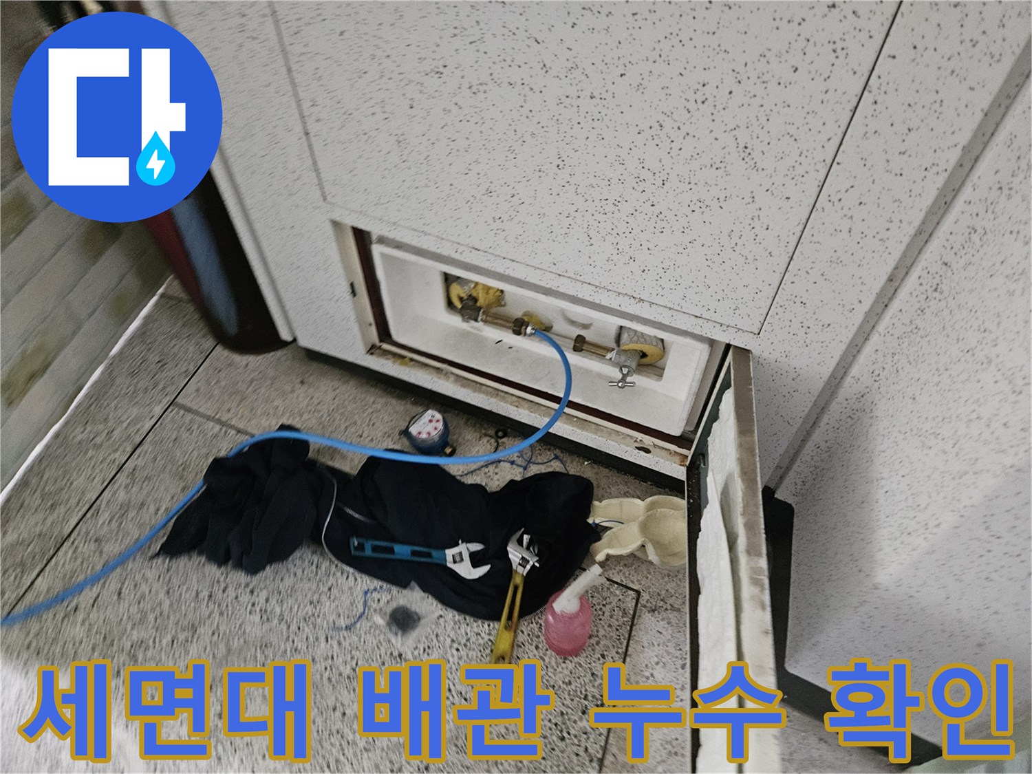 세면대 아래 배관 부속 주변의 물샘 흔적을 상세히 관찰하는 장면입니다.