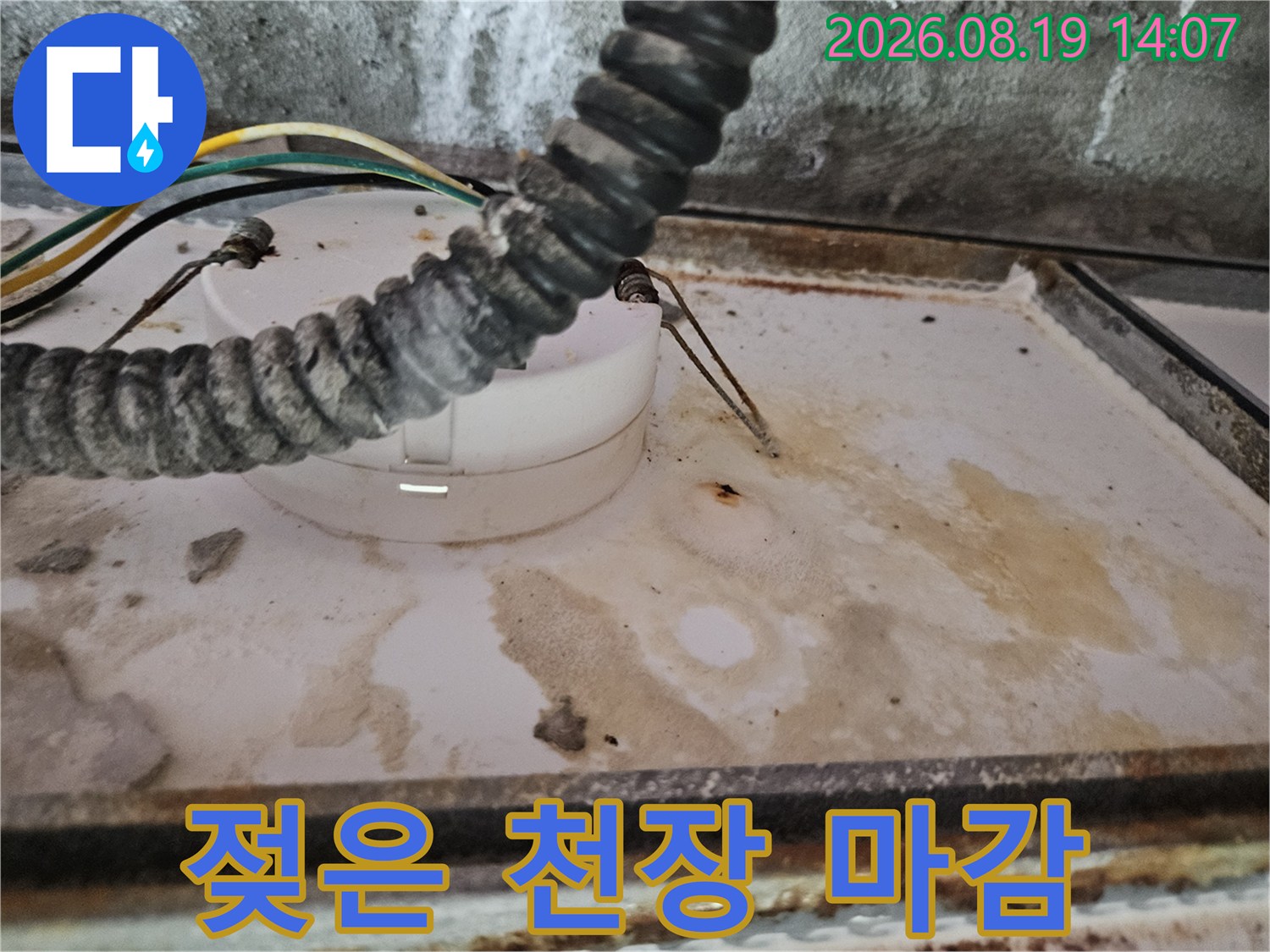 화장실 천장-물에 젖어 얼룩진 배관 주변의 마감재 상태