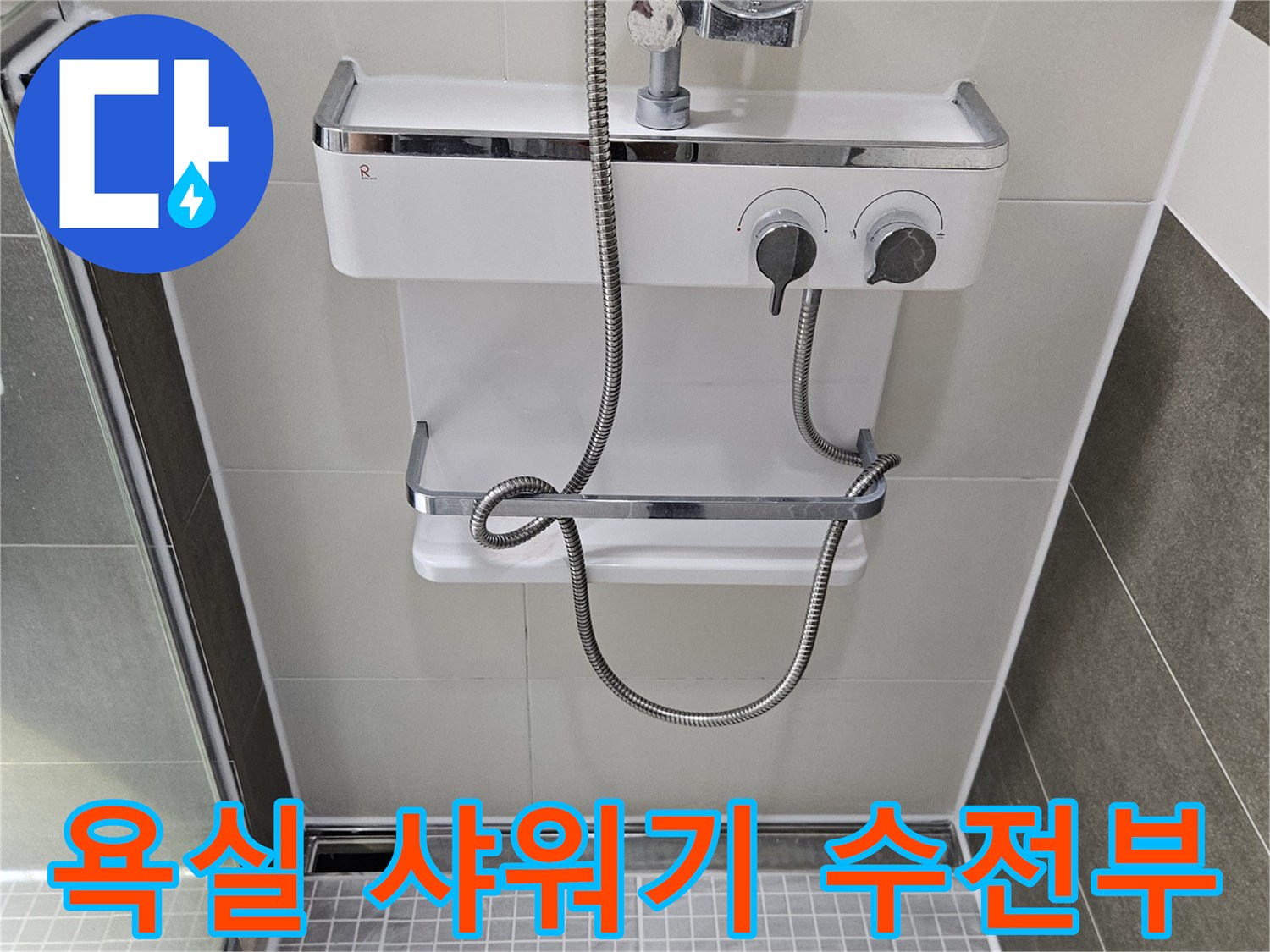 흰색 타일 배경의 샤워기 수전과 은색 호스 상세 이미지입니다.