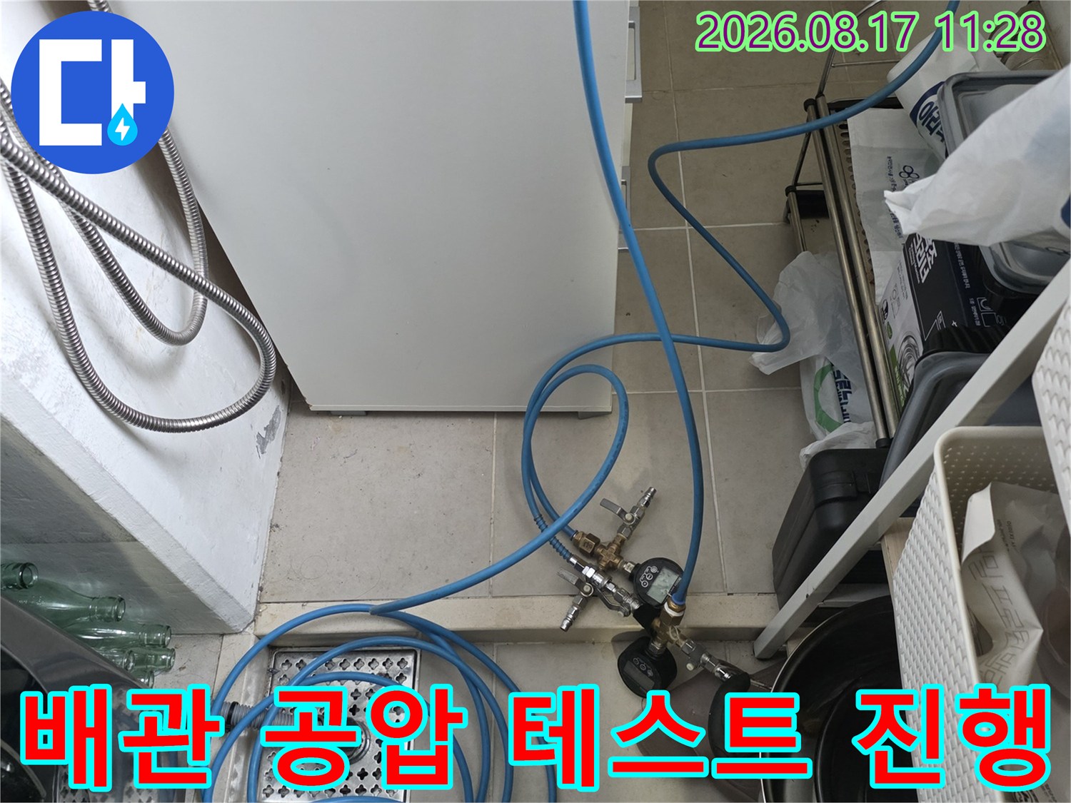 싱크대 하부 배관에 연결된 파란색 압력 측정 호스 상세 모습